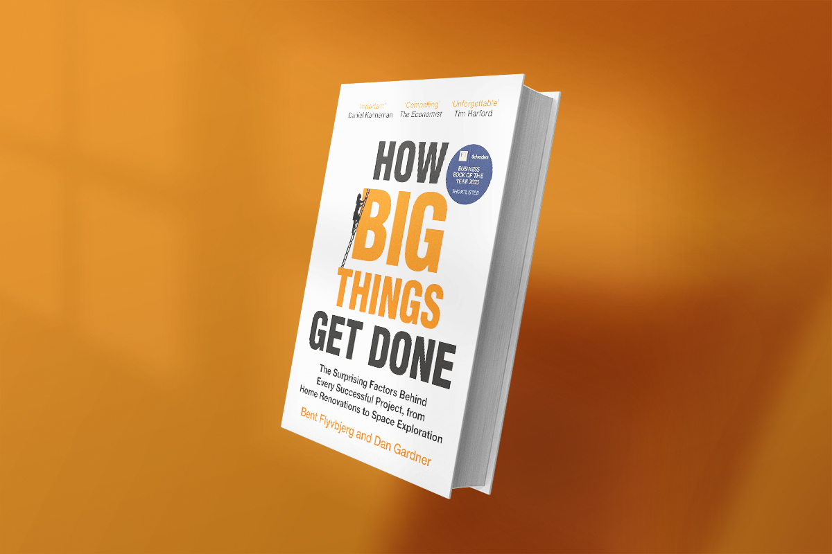 The book How Big Things Get Done by Bent Flyvbjerg and Dan Gardner has a clean white cover with bold black and orange text, offering insights into what makes large-scale projects succeed, from home renovations to space missions.