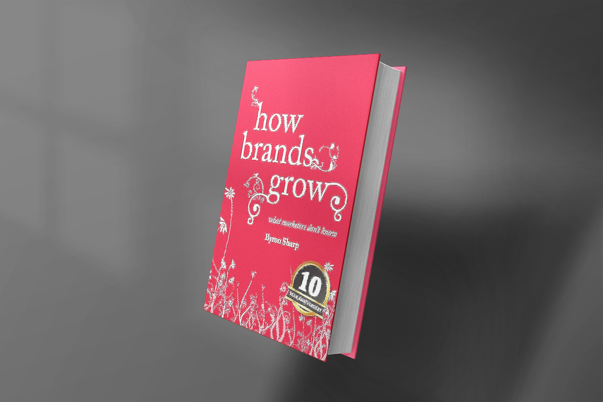 Cover of "How Brands Grow" by Byron Sharp, featuring a bright red background with white floral-like graphics and serif typography.