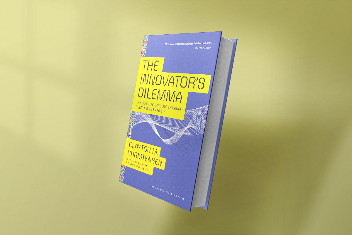 The book The Innovator’s Dilemma by Clayton M. Christensen, featuring a blue and yellow cover with abstract wave graphics, exploring why leading companies can fail by ignoring disruptive innovations.