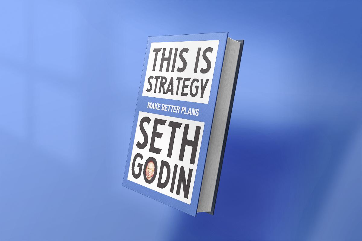 The book This Is Strategy: Make Better Plans by Seth Godin features bold black and white text on a blue background, with the author's name prominently displayed, reflecting his signature direct and motivational style.